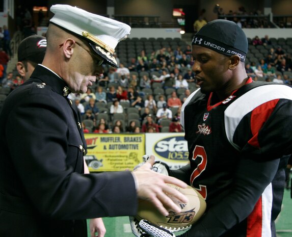 Lt. Col. Sidney McGraw receives a football from Chicago Slaughter wide receiver Dontrell Jackson before the Chicago Slaughter-Wisconsin Wolfpack Continental Indoor Football league game Saturday at the Sears Centre in Hoffman Estates, Ill. McGraw is the executive officer for Marine Air Control Group 48, the Great Lakes, Ill.-based reserve unit which served as the command element of the inaugural Marine Week Chicago. Marine Week Chicago, which concludes today, provides an opportunity for Chicago citizens to meet the men and women of the Marine Corps and learn about its history, traditions and value to the nation.