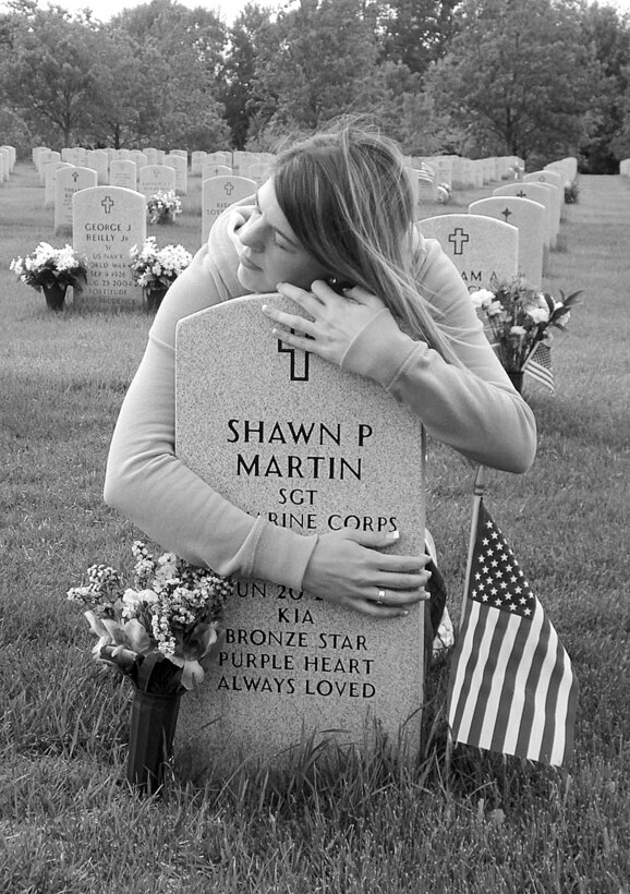 Mimi Martin embraces her husband’s grave marker during a recent visit. Her husband, Sgt. Shawn P. Martin, an explosive ordnance disposal technician, was killed in action June 20, 2007. As the two-year mark of her husband’s death approaches, Martin carries on her husband’s legacy daily with her work as the spokeswoman for the New York State Fallen Stars Memorial Project.