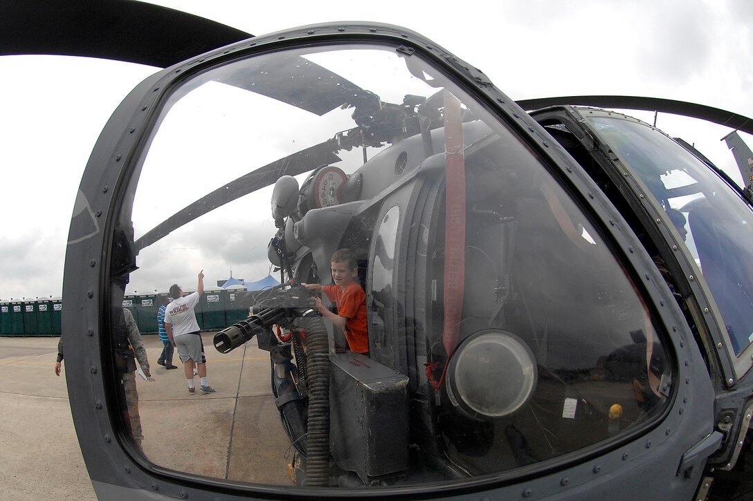 A boy plays with a mini gun on the HH-60G Pavehawk during the Joint Service Open House (JSOH) on Andrews Air Force Base, Maryland, May 15, 2009. The JSOH allows members of the public an excellent opportunity to meet and interact with the men and women of the Armed Forces. (U.S. Air Force photo by SrA Giang Nguyen)