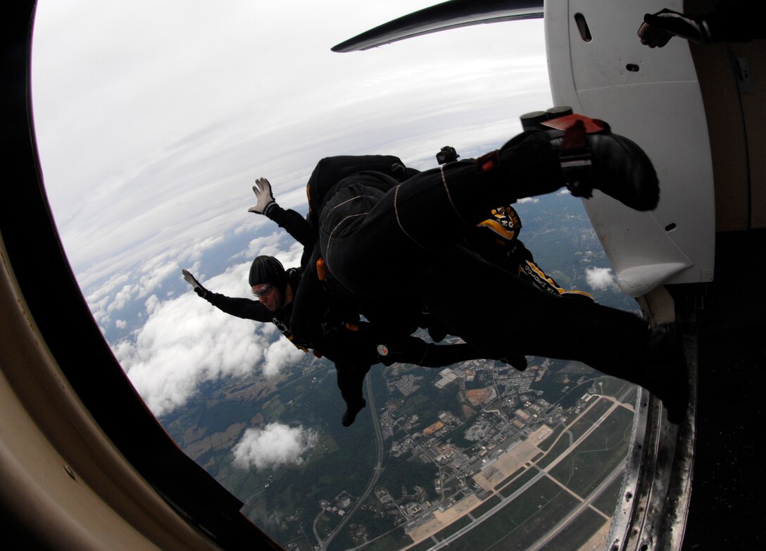Members of the U.S. Army Golden Knights jump team, demonstrate their skydiving skills at the Joint Service Open House, May 17 Andrews Air Force Base, Md. Seven Golden Knights members just hooked together in a formation followed by their camera man who jumps separate to photograph the formation in the air. (U.S. Air Force photo by Airman First Class Melissa V. Rodrigues)