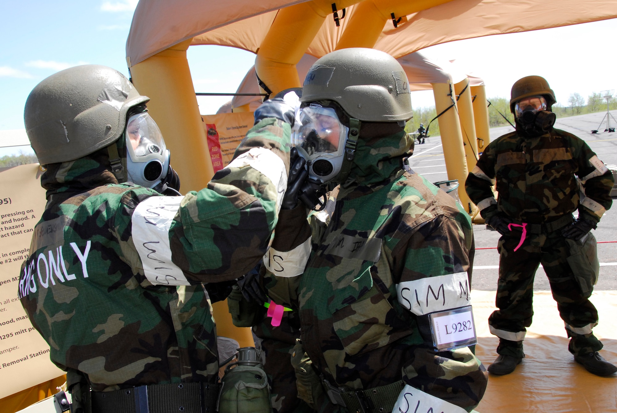 U.S. Air Force Capt. Jessica Loukinen (center), 148th Medical Group, processes through a decontamination station following simulated warfare in a chemical environment in Duluth, Minn., May 14, 2009.  The 148th Fighter Wing is conducting an Operational Readiness Exercise (ORE)  in preparation for an Operational Readiness Inspection (ORI) in August 2009.  (U.S. Air Force photograph by Senior Master Sgt. Ralph J. Kapustka)