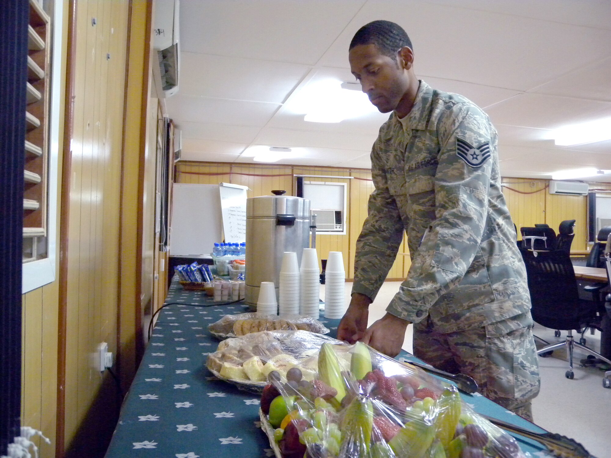 Staff Sgt. Michael Smith, 379th Expeditionary Force Support Squadron assistant facility manager, prepares a snack area for conference participants at the Freedom Conference Center here Tuesday. Sergeant Smith is a Little Rock, Ark. native deployed from the 189th Force Support Squadron at Little Rock Air Force Base, Ark. (U.S. Air Force photo by Tech. Sgt. Shad Eidson/released)