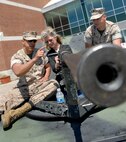 Corporals Omar Marcias, mimms clerk, 2nd Battalion 24th Marines, Chicago, and Eric Weedman, supply administartion, 2nd Battalion 24th Marines, Chicago, explain the properties of the Browning M2 .50 Caliber Machine Gun to Cyndi Fullerton from Wheaton, Ill., May 17 during Marine Week. The high mobillity multipurpose wheeled vehicle and a weapons display was at the Navy Pier throughout the weekend.