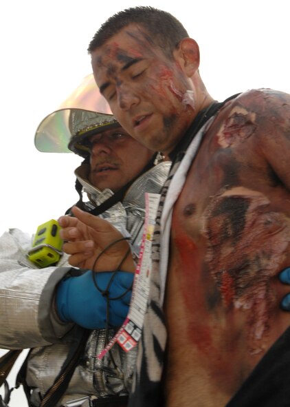 A firefighter from the March Air Reserve Base Fire Department moves a "casualty" so that he can be treated for wounds inflicted during a simulated C-17 crash as part of the MARE or Major Accident Response Exercise. The MARE tests March ARB, City and County of Riverside, City of Moreno Valley, City of Perris, Cal Fire and American Medical Response, all of Southern California, to respond and recover from a aircraft accident involving mass casualties. (U.S. Air Force photo by SSgt Stephen Schester)