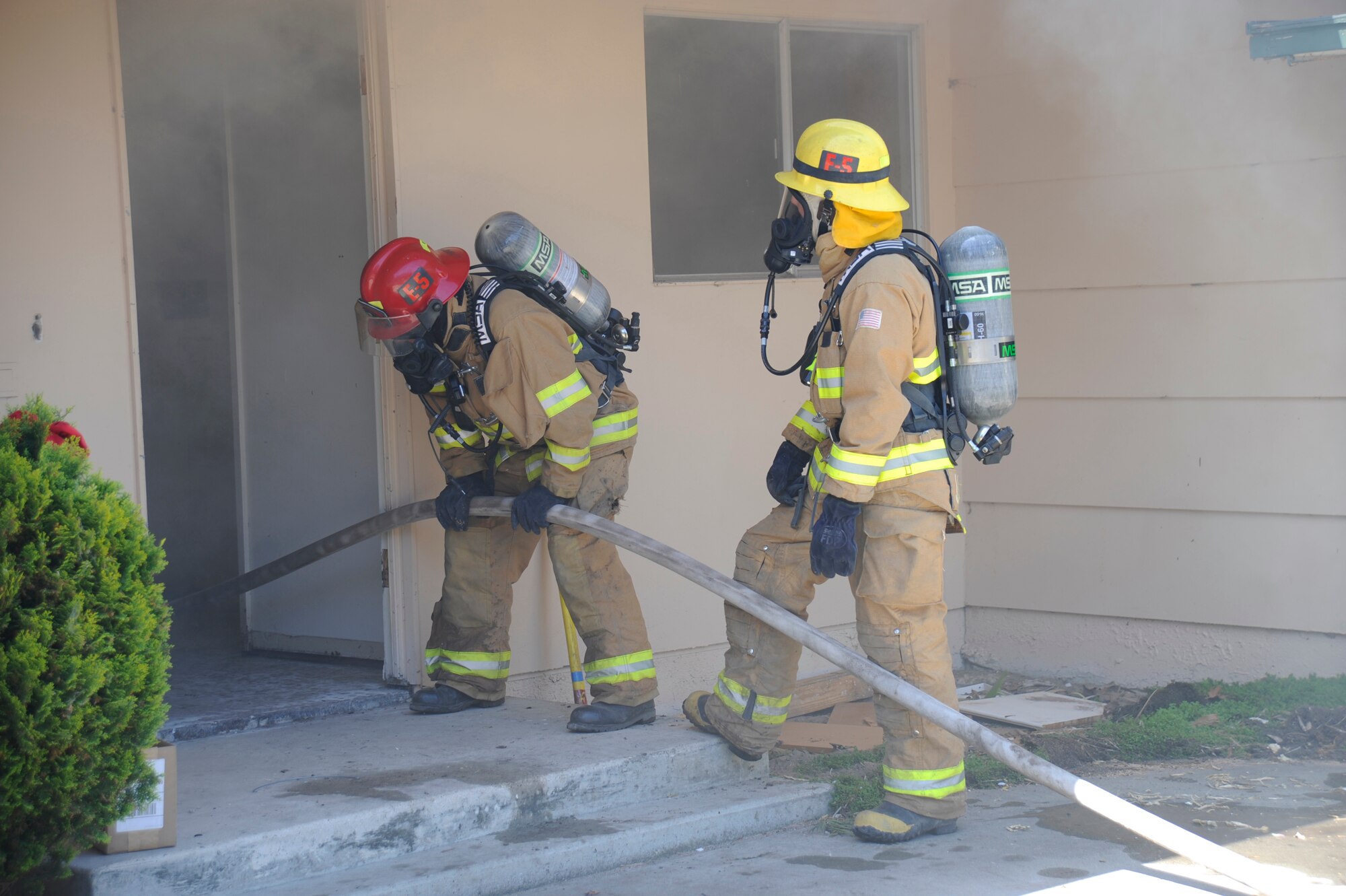VANDENBERG AIR FORCE BASE, Calif. -- Vandenberg firefighters use a traditional water hose to put out a fire in east housing here May 12. Members of the Air Force Research Laboratory and the Vandenberg fire department are testing a high-pressure nozzle system versus a traditional nozzle system. The test was to determine if the high-pressure hose could work in structural fires. ( U.S. Air Force photo/Senior Airman Stephanie Longoria)