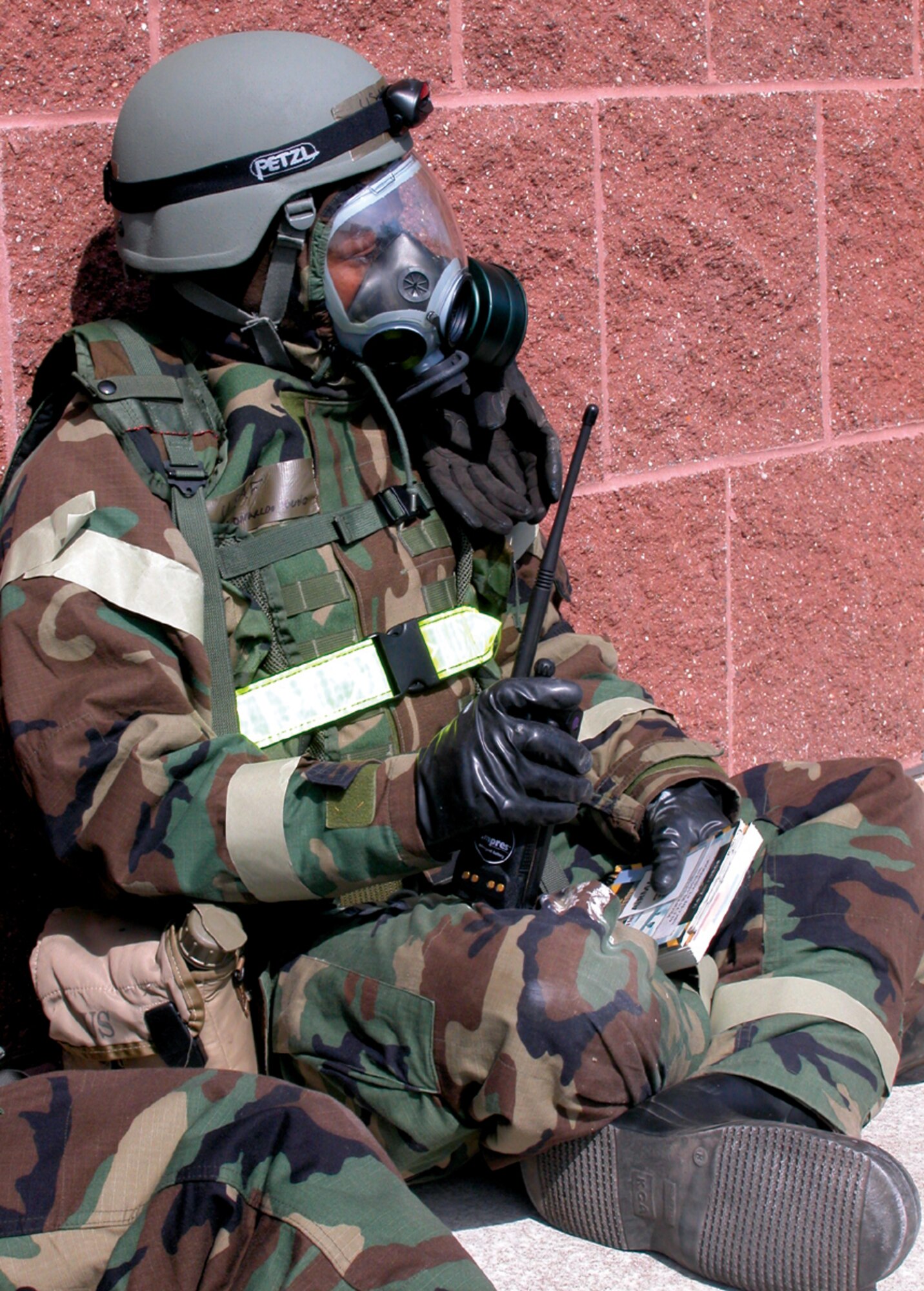 An Airman in full protective gear awaits further instructions after a "bugout" exercise at Alpena Combat Readiness Training Center May 5.  The mobility exercise combined active-duty and Reserve Airmen from McChord Air Force Base , Wash., and Grand Forks Air Force Base, N.D. (U.S. Air Force photo/Staff Sgt. Grant Saylor)