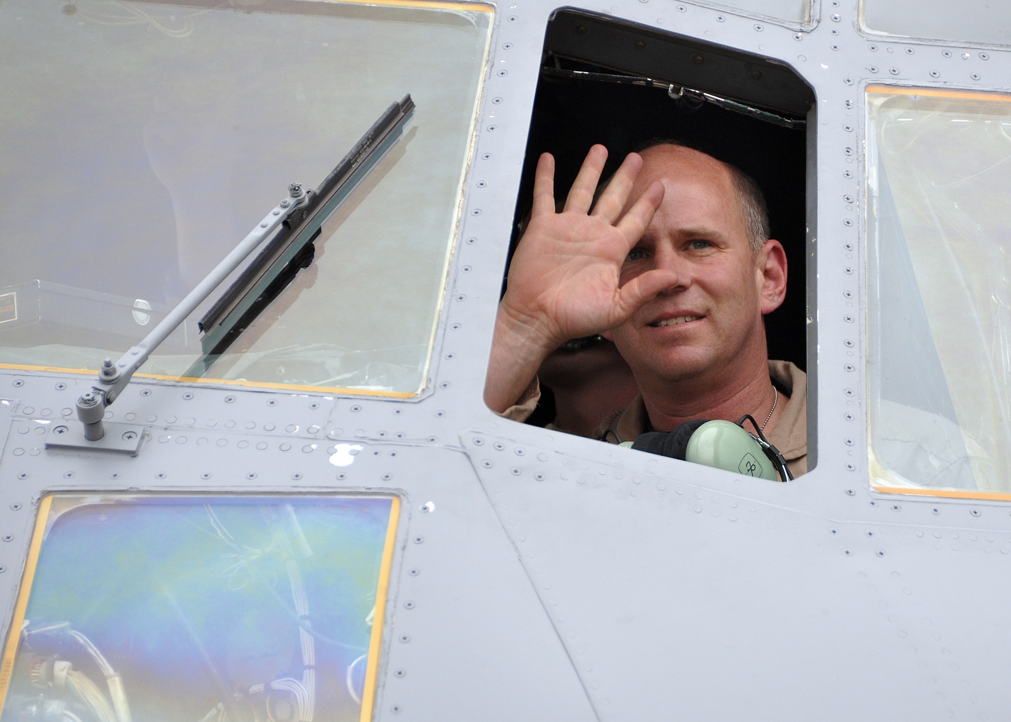 Lt. Col. Marc Hall waves to his family from the cockpit of a C-130 on May 14. Colonel Hall and more than 200 other Kentucky Air National Guardsmen just completed a two-month Air Exeditionary Force deployment to Afghanistan. (U.S. Air Force photo/Airman 1st Class Maxwell Rechel.)