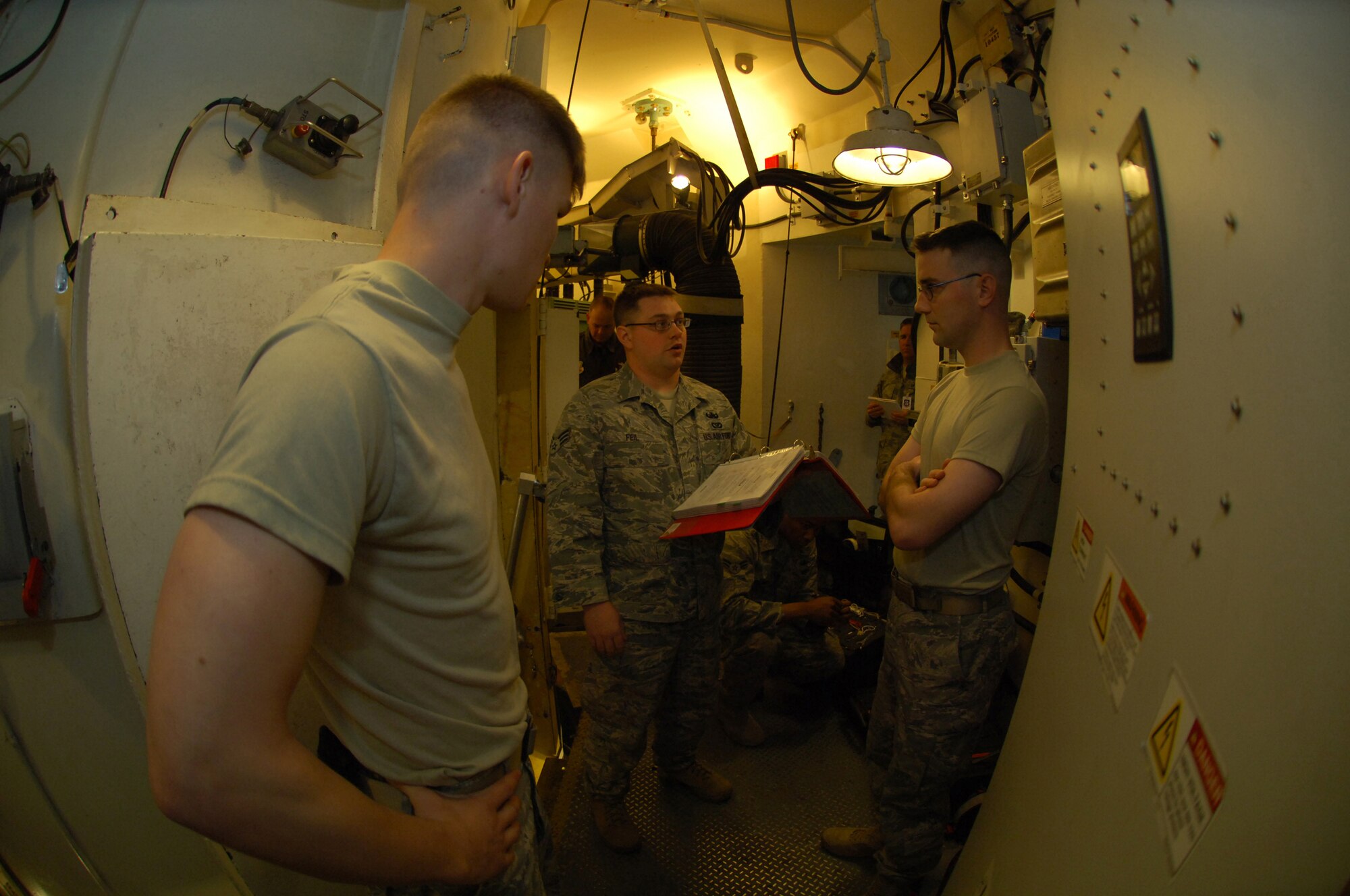 MINOT AIR FORCE BASE, N.D -- Senior Airman Aaron Feil (center) conducts a safety brief with Senior Airman Kyle McGann and Senior Airman James Tucci, all of the 5th Civil Engineer Squadron’s explosive ordnance disposal team, during the Nuclear Surety Inspection here, May 15.  An NSI is designed to evaluate a unit's readiness to execute nuclear operations. Areas to be evaluated during the NSI include operations, maintenance, security, and support activities needed to ensure the wing performs its mission in a safe, secure and reliable manner. This no-notice inspection is expected to conclude May 22. (U.S. Air Force photo by Tech. Sgt. Lee A. Osberry Jr.)