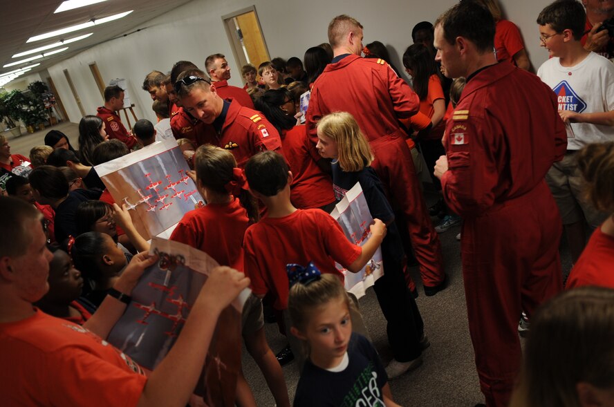 The Canadian Snowbirds autograph posters and pamphlets for 5th graders from the Starbase youth center on Barksdale AFB durning the Defenders of Liberty Air Show, May 8.  (United States Air Force photo by Senior Airman Alexandra Sandoval) (RELEASED)
