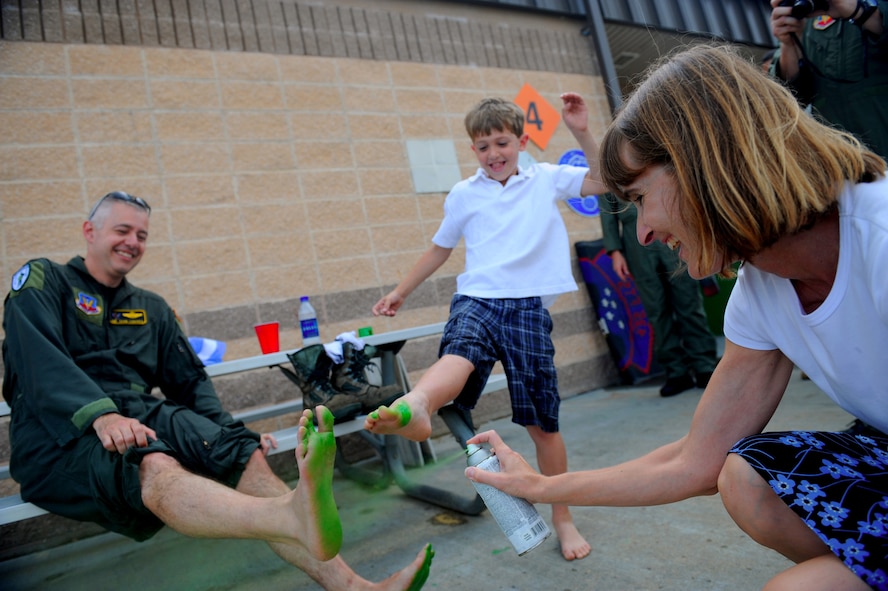 MOODY AIR FORCE BASE, Ga. -- Col. Kenneth Todorov, 23rd Wing commander, has his feet spray painted green by his wife Lynn before putting them on to a ceiling tile here May 14. The green feet are a rescue community symbol that originated from the Jolly Green Giants during Vietnam. (U.S. Air Force photo by Senior Airman Gina Chiaverotti)