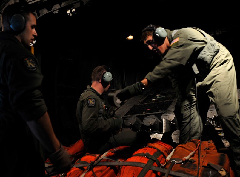 MOODY AIR FORCE BASE, Ga. -- Staff Sgt. Jeremy Rice, Senior Airman Richard Oliver, and Airman 1st Class Jacob Dattage, 71st Rescue Squadron HC-130P/N Combat King loadmasters, load a flare launcher system with Mark 25 short smokes and one sea dye during a search and rescue mission over the Atlantic Ocean May 14. In the event a person is spotted during the search, the dye and one of the smokes would be dropped to mark the location. (U.S. Air Force photo by Senior Airman Schelli Jones)