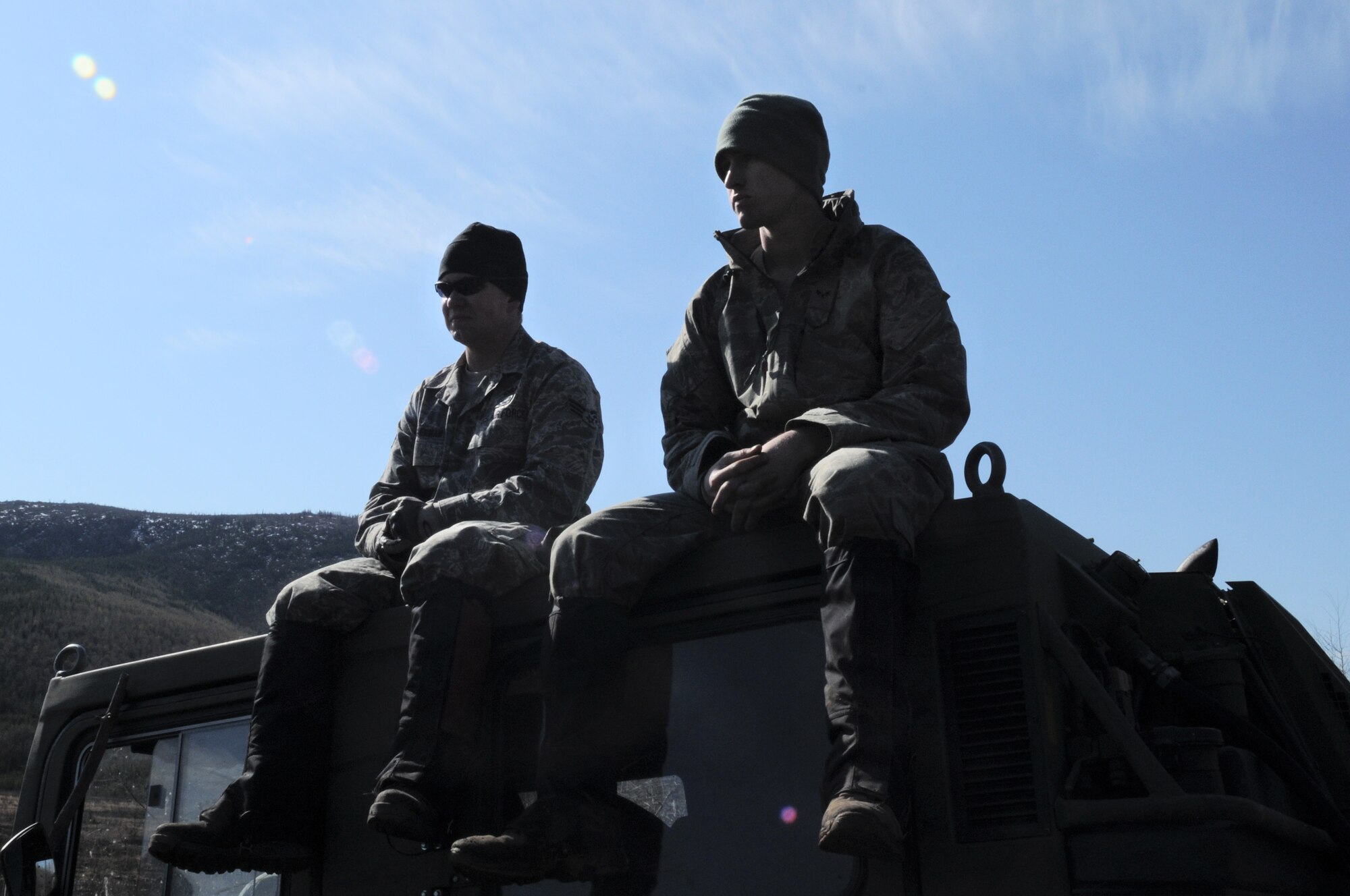 Senior Airman Matthew Leatherman and Airman 1st Class Brandon Wood rest on a vehicle May 14, 2009, Pacific Alaskan Range Complex. The Airmen are taking a break after surveying the Range for unexploded ordnance. The Airmen are with the 354th Civil Engineering Squadron Explosive Ordnance Flight. (U.S. Air Force photo/Airman 1st Class Laura Max)