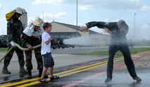 MOODY AIR FORCE BASE, Ga. -- Col. Kenneth Todorov, 23rd Wing commander, is sprayed with water by his son Aiden after his final HH-60G Pave Hawk helicopter flight here May 14. Colonel Todorov’s next assignment will be at U.S. Northern Command at Peterson Air Force Base, Colo. (U.S. Air Force photo by Senior Airman Brittany Barker) 