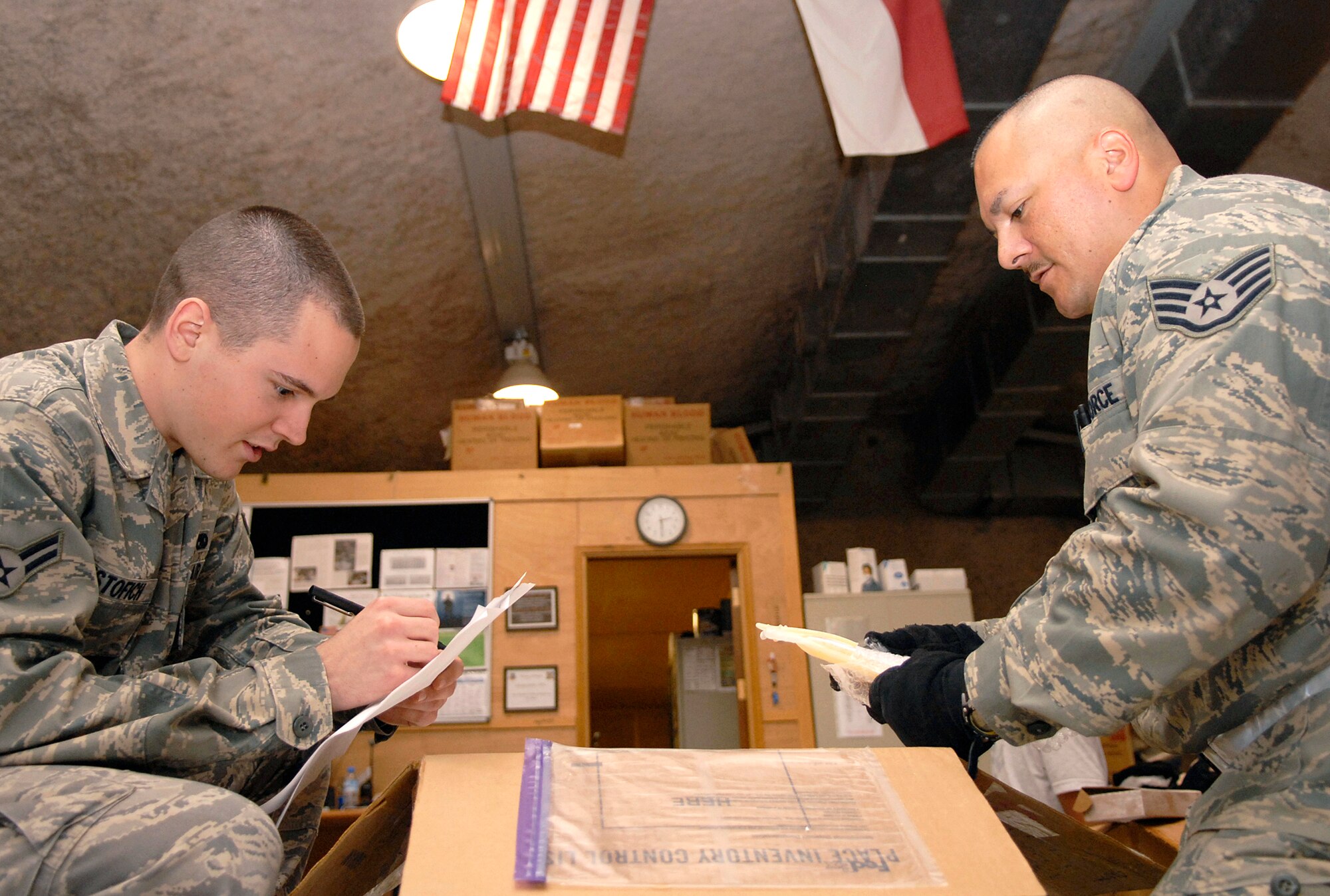 Airman 1st Class Benjamin Cristofich (left) and Staff Sgt. James Palapas, both volunteers from the 71st Expeditionary Air Control Squadron at this air base in Southwest Asia, assist the 379th Expeditionary Medical Group Blood Transshipment Center staff in inventorying frozen plasma May 9 to ensure it is ready to be distributed throughout the U.S. Central Command area of operation. (U.S. Air Force photo/Senior Airman Andrew Satran)
