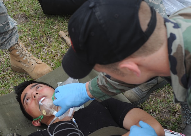 Airman 1st Class Gabriel Herr gives oxygen to Airman 1st Class Shon Gilliand after a simulated bomb exploded on Charleston AFB May 13. The simulated blast was part of an emergency management inspection to test first responders on the scene. Airman Herr is with the 437th Medical Group and Airman Gilliand is with the 437th Aircraft Maintenance Squadron. (U.S. Air Force photo/Senior Airman Katie Gieratz)