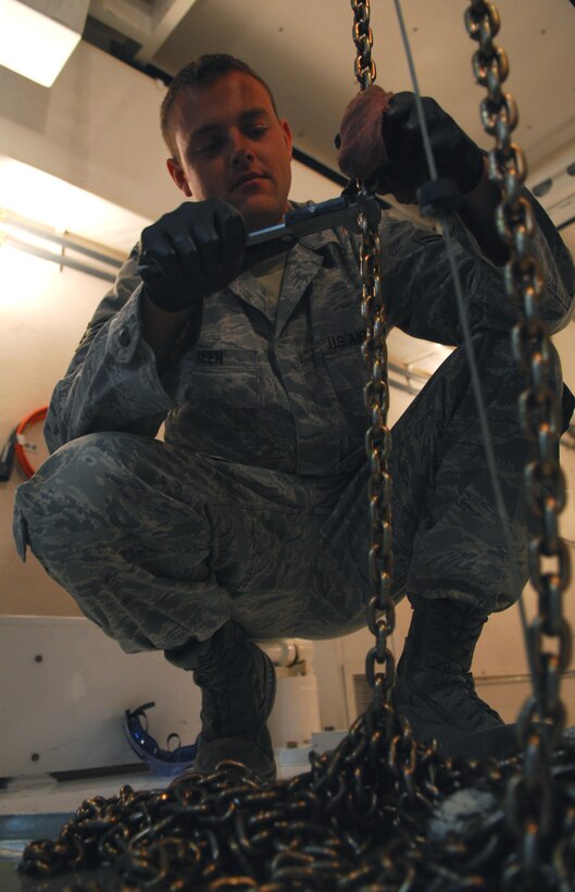 VANDENBERG AIR FORCE BASE, Calif. -- Going link by link, Senior Airman Colby Green of the 576th Flight Test Squadron executes a hoist chain inspection on a payload transporter during an annual inspection here May 14. (U.S. Air Force photo/Senior Airman Christopher Hubenthal)