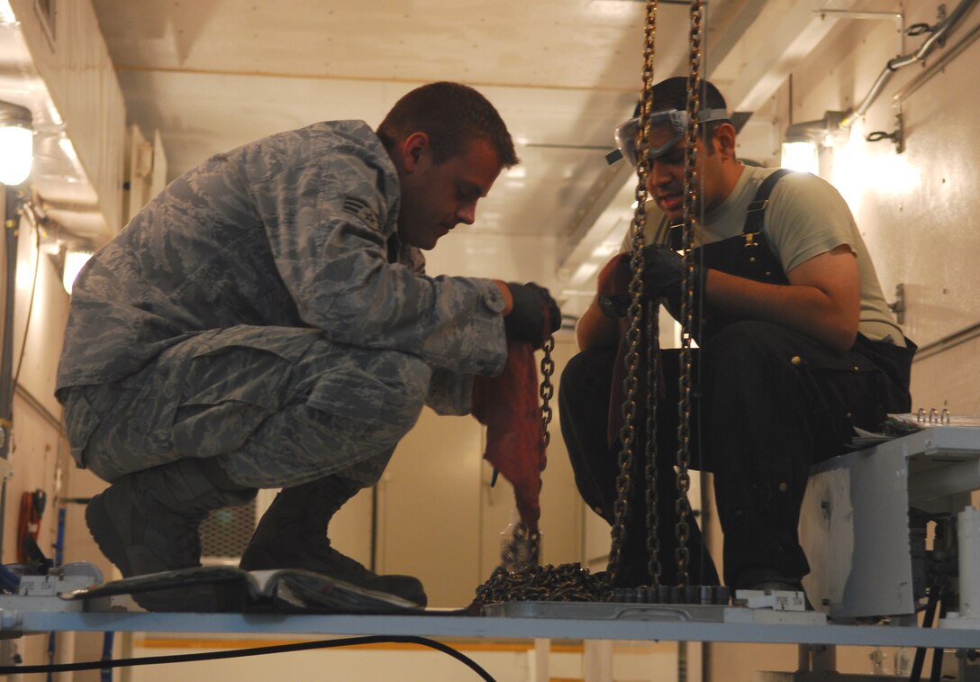 VANDENBERG AIR FORCE BASE, Calif. -- Senior Airman Colby Green (left) and Staff Sgt. Carlos Laurencio (right), both of the 576th Flight Test Squadron, prepare to execute a hoist chain inspection here May 14. (U.S. Air Force photo/Senior Airman Christopher Hubenthal)
