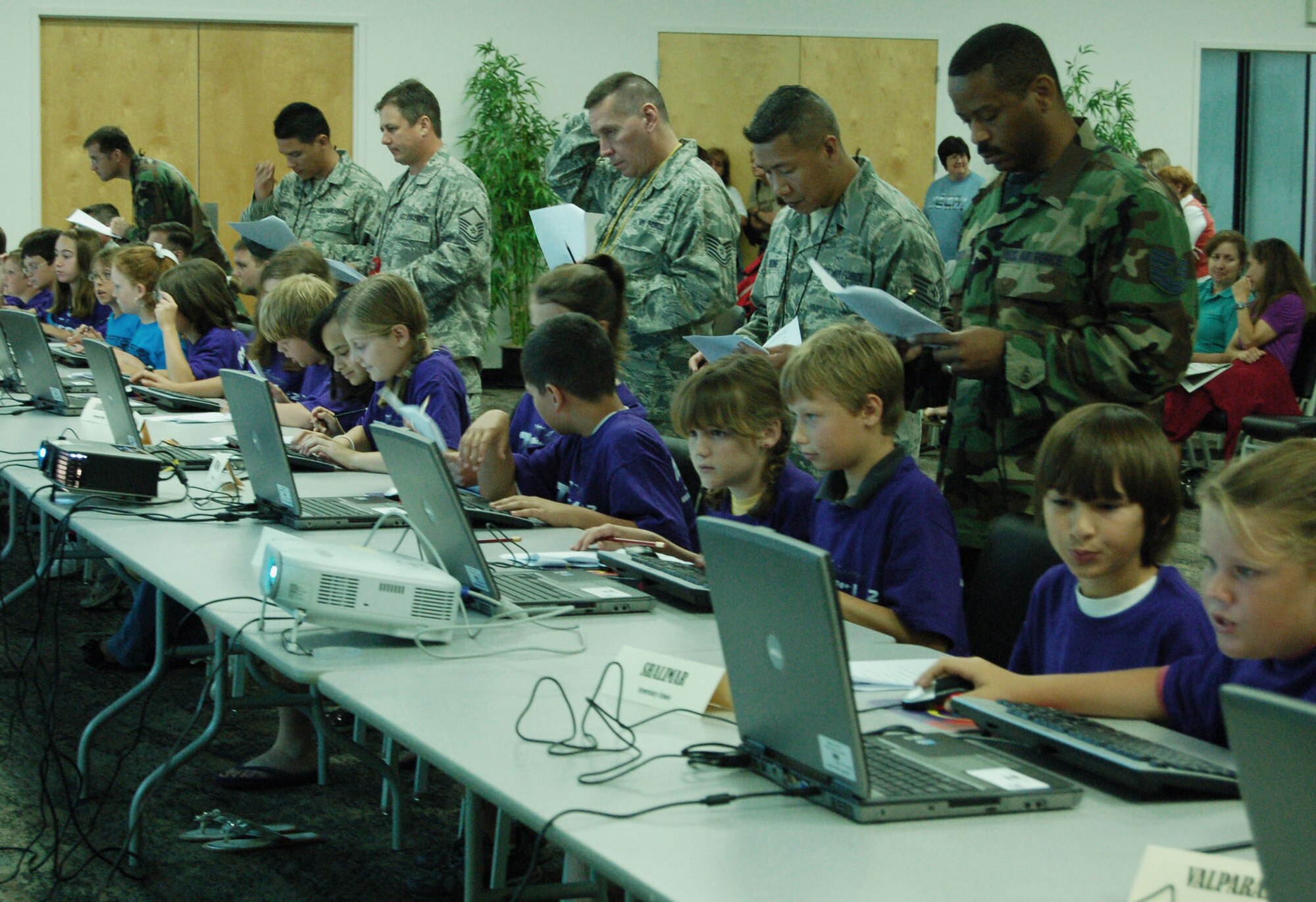 DUKE FIELD, Fla. -- From left, Air Force Reserve Tech. Sgts. Jeff March, Mark Wong, and Xavier Salgado, Master Sgt. Joe Dunn, and Tech. Sgts. Teddy Batarao and Forest Webb, all from the 919th Communications Squadron, mentor elementary students by judging their “internet scavenger hunt,” one of many events at Okaloosa County Schools’  10th-Annual Tech Bowl held recently in the Niceville Community Center.   Students were given 30 minutes to surf the Internet to answer 45 questions without using “Wiki” sites or search engine pages.  This was the 10th-consective Tech Bowl that Duke Field’s communicators have volunteered their expertise to support the computer-focused technology event.  (Courtesy photo)