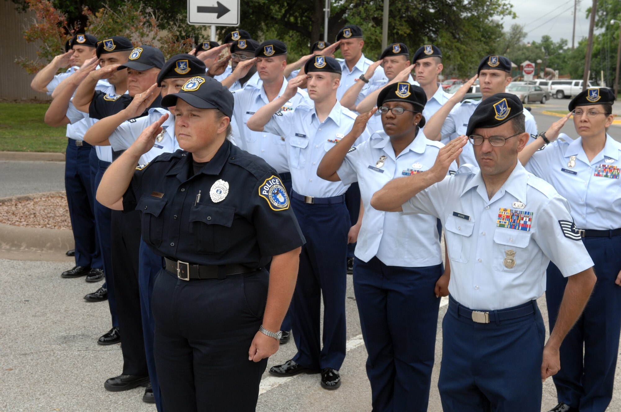Members of the 17th Security Forces Squadron salute as the flag in front of the San Angelo Police Department is lowered to half-staff for National Police Week May 11. Police Week, as well as National Peace Officers’ Memorial Day, May 15, honor those officers who have fallen in the line of duty. (U.S. Air Force photo by Tech. Sgt. John Barton)