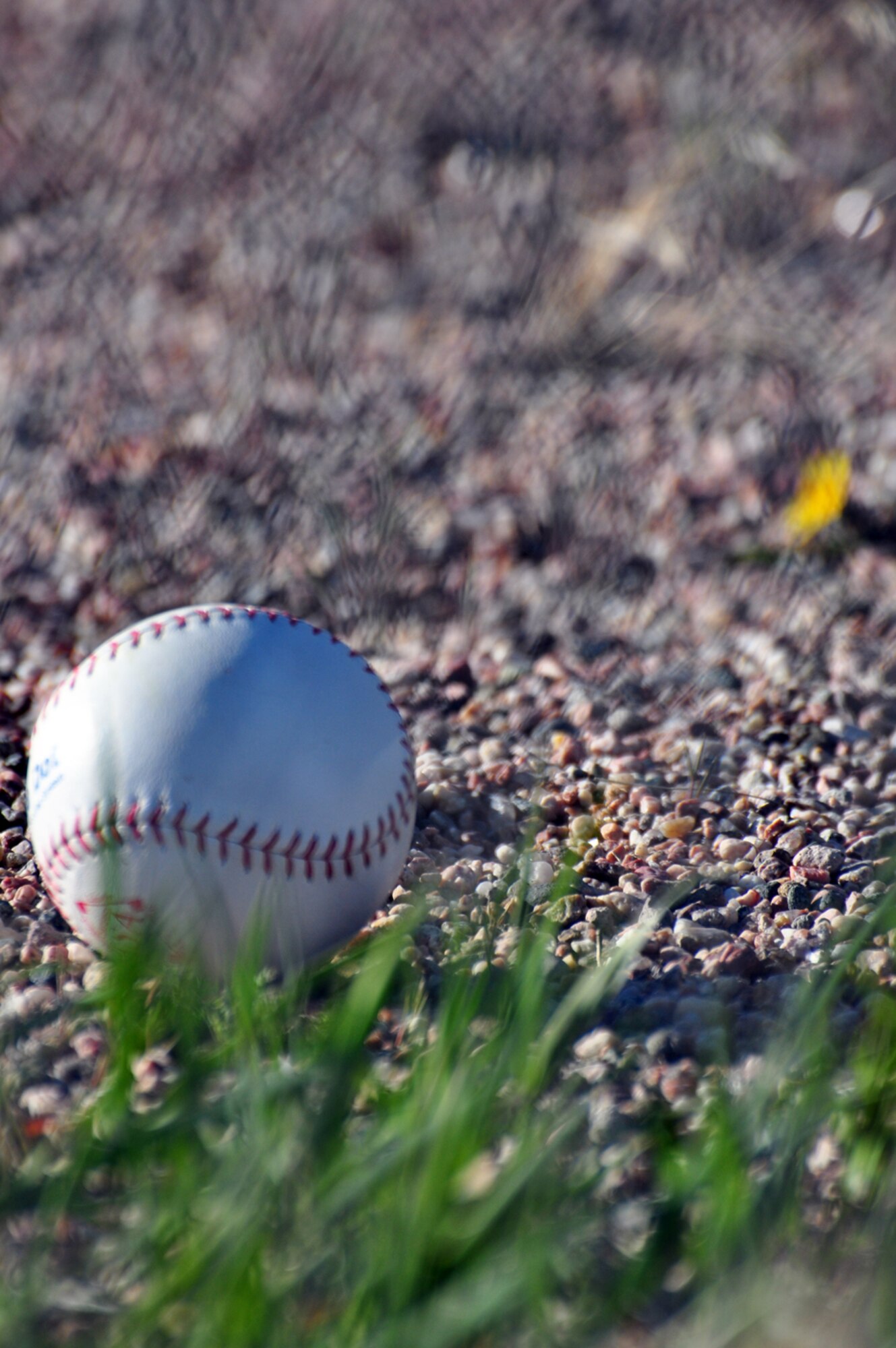 A ball rests on the warning track of the 300-foot softball field. The Wyoming wind wreaked havoc for the batters during the tournament, challenging them to put an extra effort behind their swings.