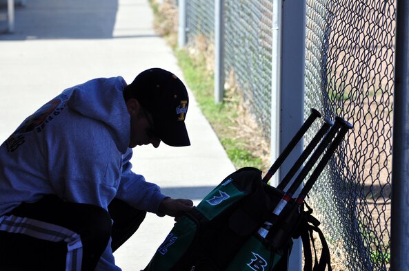 Airman 1st Class Mike Lockart, 320th Missile Squadron, looks for his glove in his equipment bag during Warren’s softball home run derby at Freedom Hall Fitness Center May 8.
