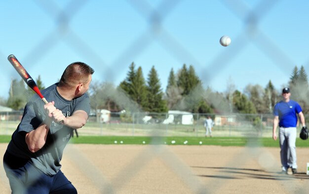 Senior Airmen Kevin Comeaux, 319th Missile Squadron, stares down a pitch from Senior Airmen Michael McMillen, 90th Force Support Squadron, during Warren’s home run derby May 8 at the Freedom Hall Fitness Center softball field one. The tournament was a two-round event. The first round was 10 outs. Anything hit that was not a home run was considered an out. Round two was based on seven outs. Duvale Brown, the winner of the event, received a $50 AFFES gift certificate (U.S. Air Force Photos/Staff Sgt. Chad Thompson).