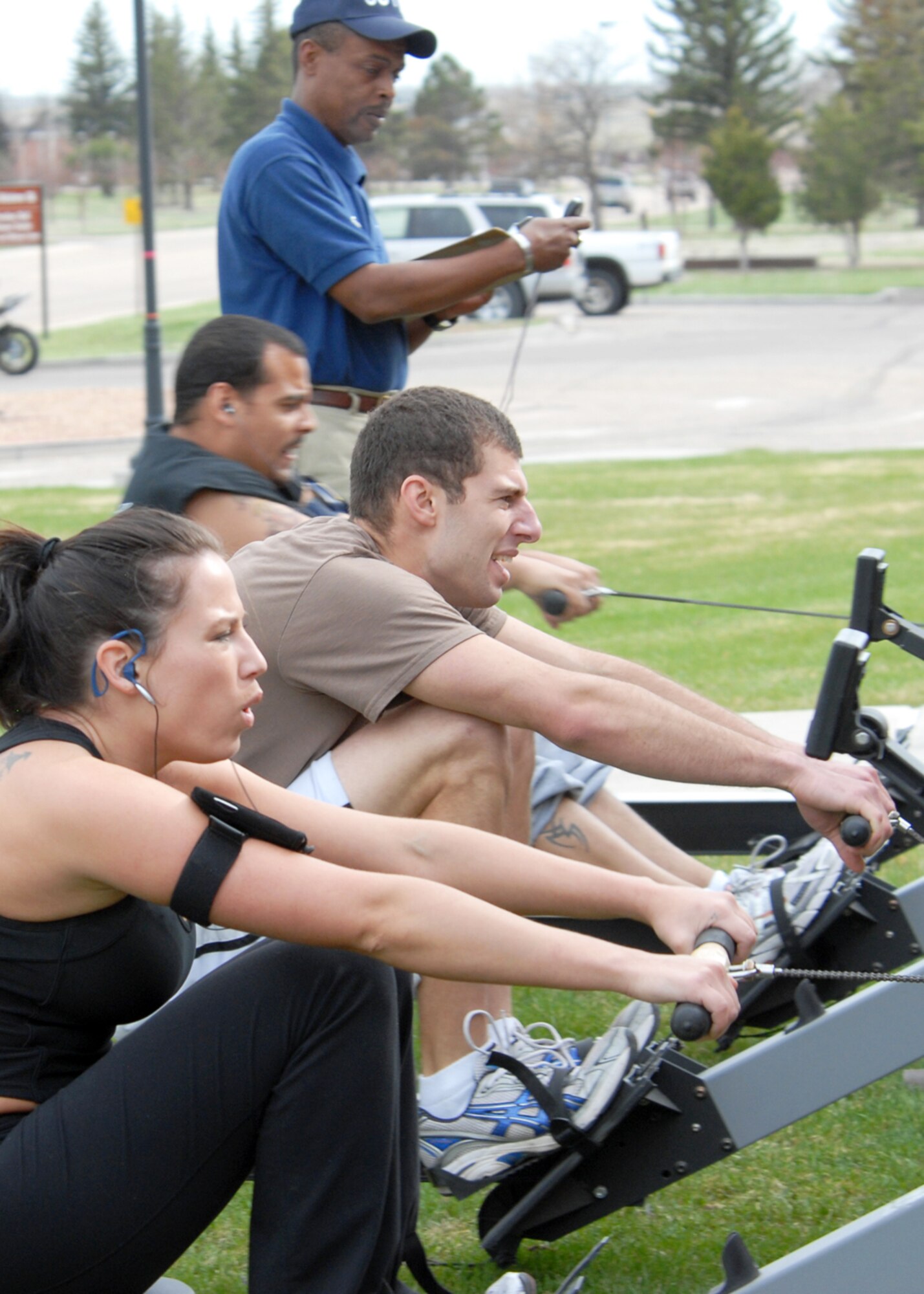 Airman Tran, Lieutenant  Sherman and Lieutenant Mercado compete in the first heat of the 500-meter row during the Warren’s Fittest challenge.