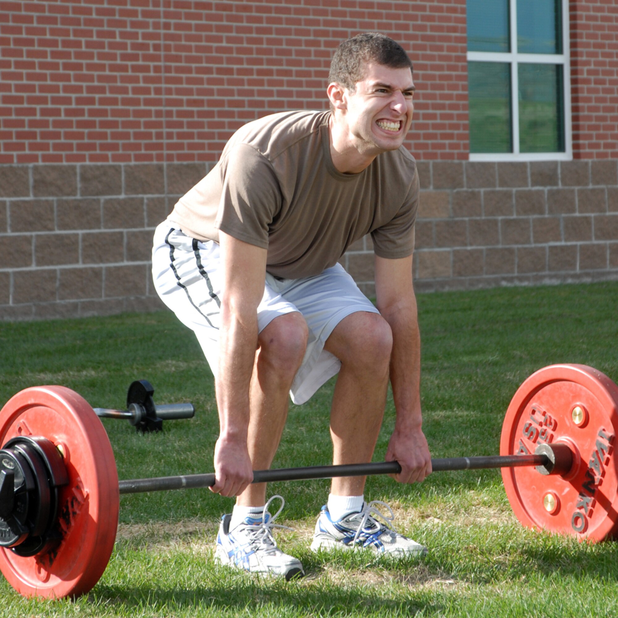 2nd Lt. Mike Sherman, 319th Missile Squadron grunts as he lifts his weight during the body weight deadlift portion of the fitness challenge.