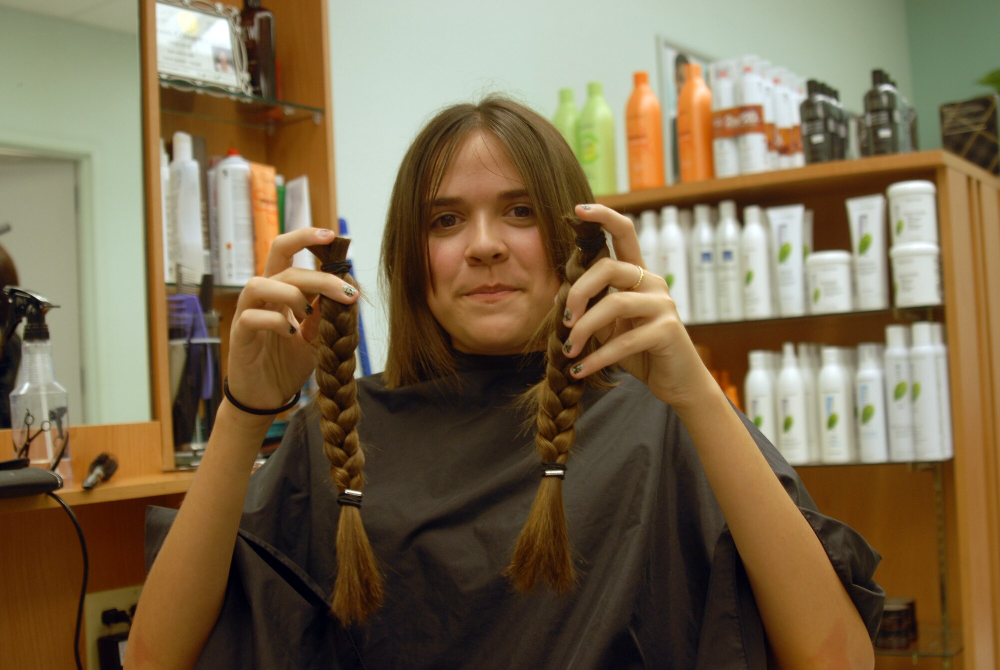 Amanda Medina, an Air Force dependent, holds the 10-inch ponytails she donated to Locks of Love. (U.S. Air Force photo by Airman 1st Class Anne Gathua)
