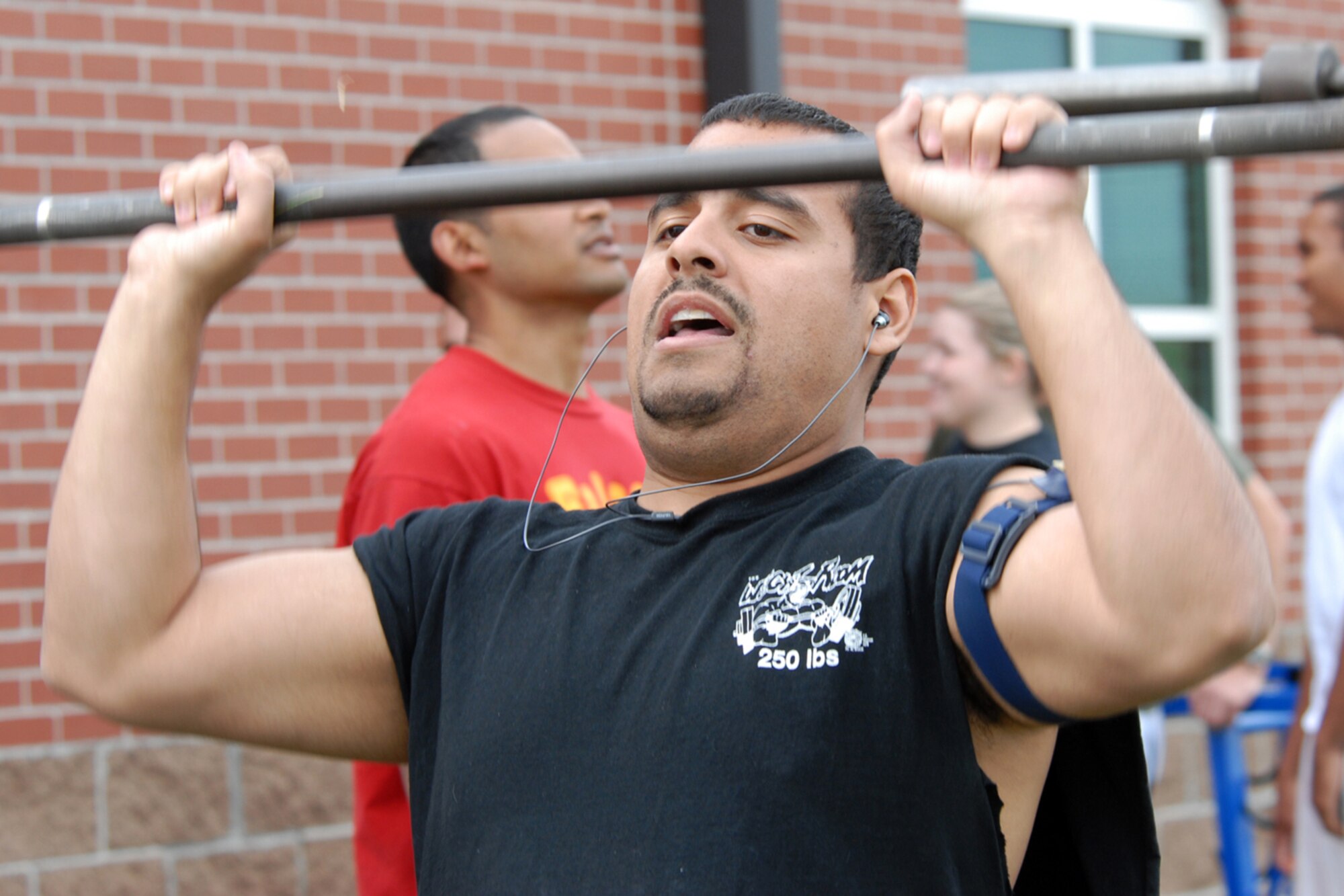 1st Lt. Doug Mercado, 90th Operations Support Squadron, pushes the weight above his head during the shoulder press portion of the completion.