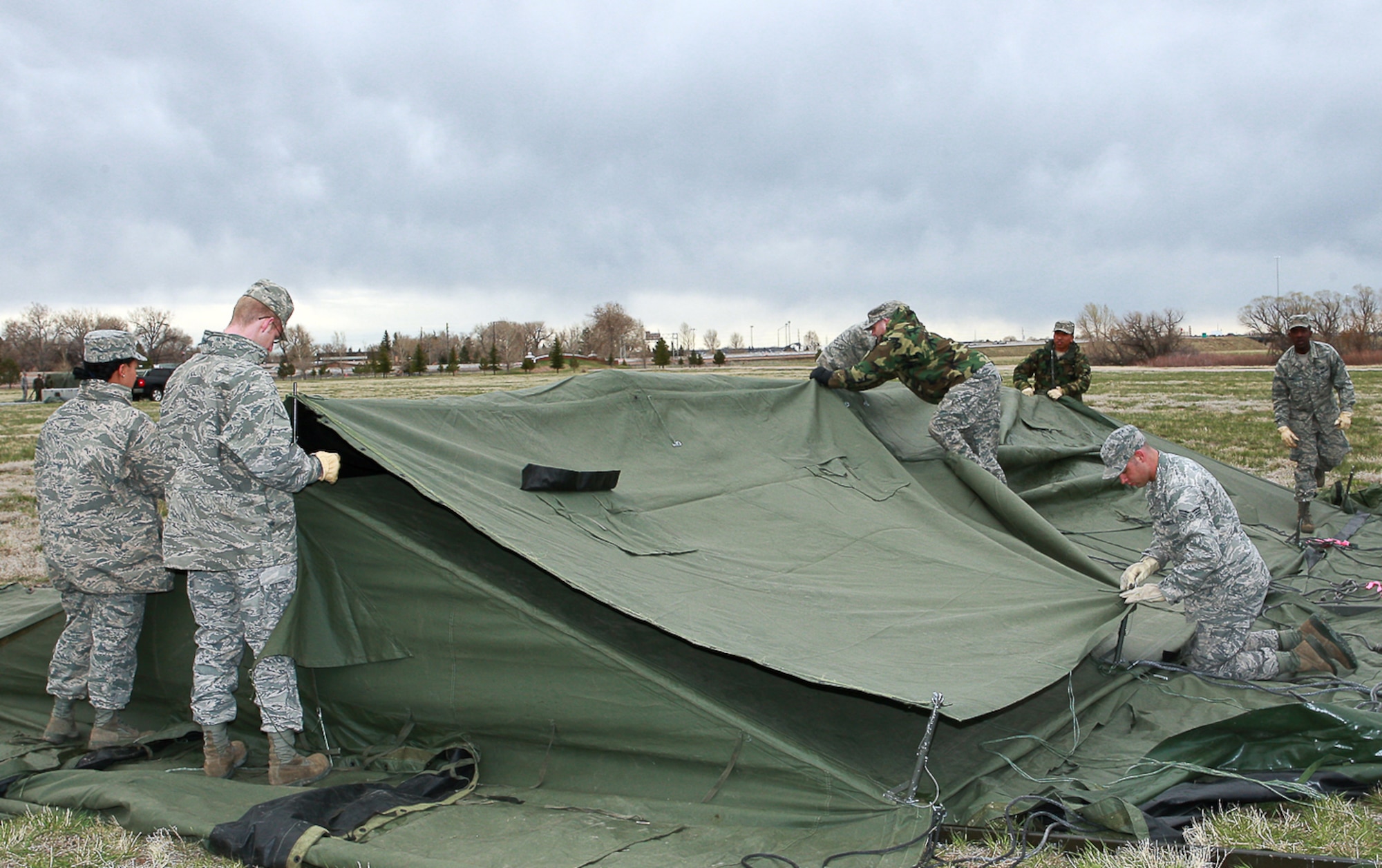 Airmen assemble a temper tent during the setup for an exercise May 4 behind the Trail’s End Club. The exercise was used to test the initial response force and other key areas during a possible terrorist attack at a missile site (U.S. Air Force Photo/Jeff Allred).