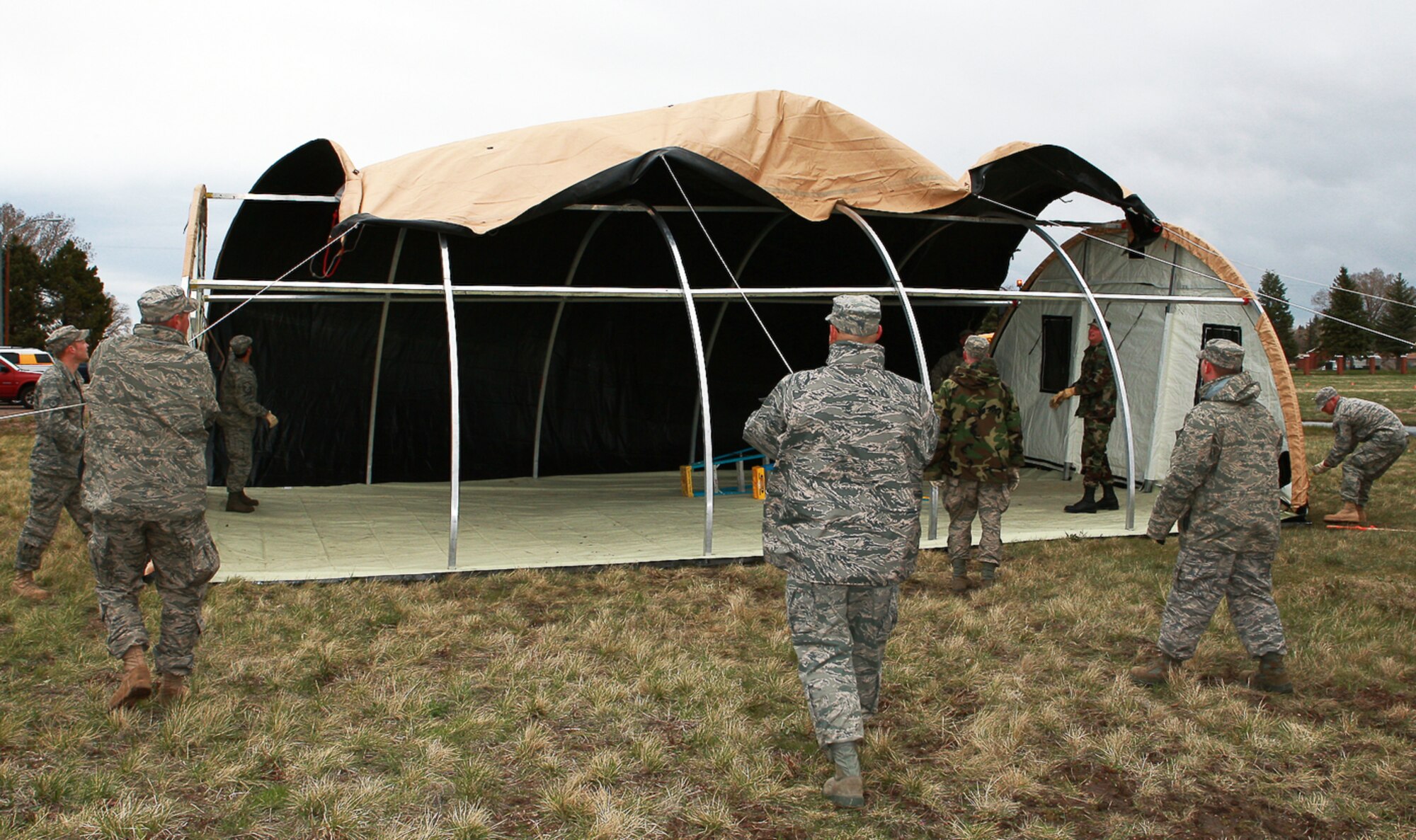 Airmen erect an Alaskan tent during the setup for an exercise May 4 behind the Trail’s End Club (U.S. Air Force Photo/Jeff Allred).