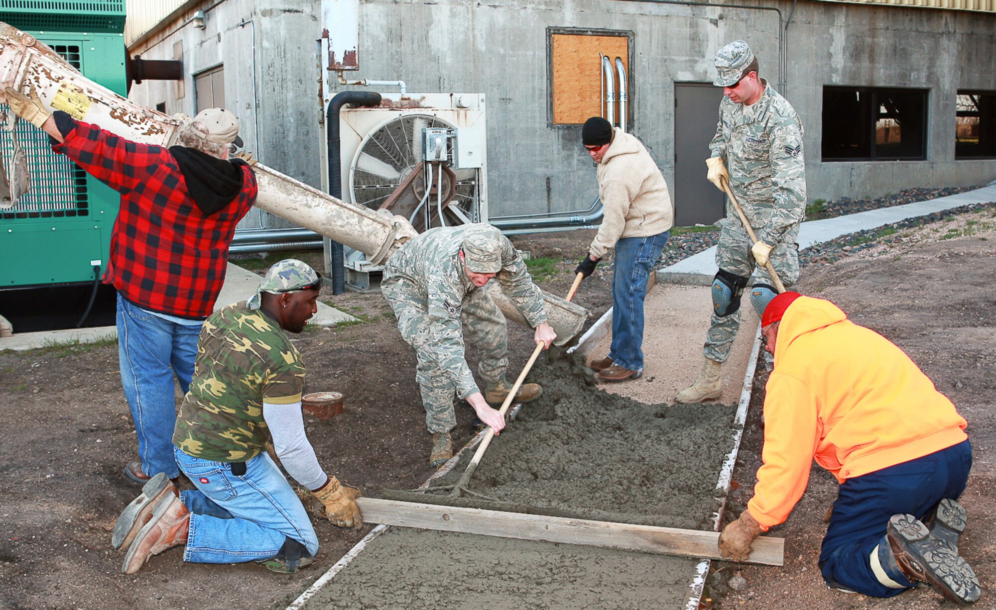 Members of the Pavement and Equipment Team pour, distribute and level concrete May 8 near Bldg. 660 to extend a drainage area.  Part of the project was completed last year, but an extension was needed to ensure proper drainage during inclement weather (U.S. Air Force Photos/Jeff Allred).
