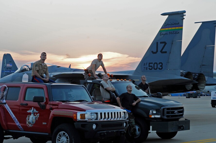 U.S. Marine Corps Sergeant Earnest Barnes (left to right), Marine Corps Recruiting Service, U.S. Air Force Senior Airman Jacob Foster, Staff Sgt. Robert Wheeler, Staff Sgt. Philip Hovey and Senior Airman Michael Josey of the Aerospace Ground Equipment section of the 2d Maintenance Squadron watch a flying demonstration during the twilight show of the Defenders of Liberty Airshow, May 8.  (U.S. Air Force photo by Tech. Sgt Laura K. Deckman)(released))