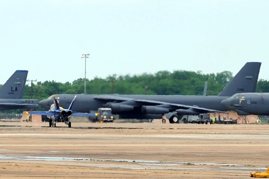 A U.S. Navy Blue Angels F/A-18 Hornet taxis past 2d Bomb wing B-52 bombers during a practice flight preparing for the 2009 Defenders of Liberty Air Show here.  The air show is held May 9 and 10 and is open to the public. (U.S. photo by Airman 1st Class Brittany Y. Bateman)(RELEASED)