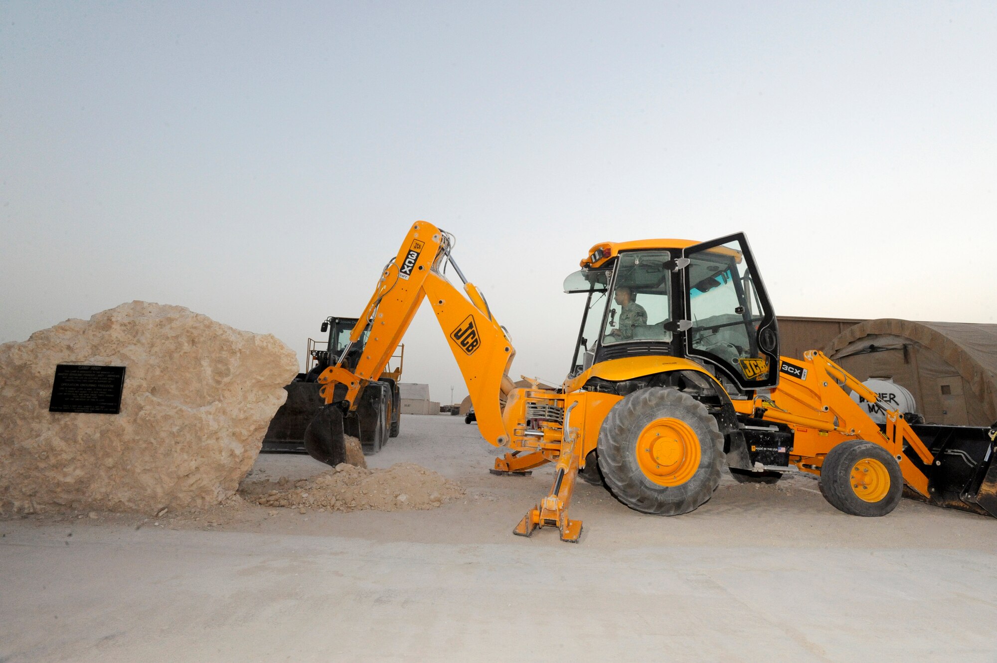 Tech. Sgt. Peter Lagos, a pavement and equipment operator better known as a "dirt boy" from the 379th Expeditionary Civil Engineer Squadron, breaks ground using a back hoe to move the memorial stone for Master Sgt. Evander E. "Andy" Andrews here, May 15, 2009, in and undisclosed location in Southwest Asia.  The memorial stone will be placed in front of the coalition compound movie theater and the theater will be renamed the Master Sgt. Evander E. "Andy" Andrews Memorial Theater once the stone is in its final resting place; Master Sgt. Andrews was Operation Enduring Freedom's first fatality. Sergeant Lagos is native to San Jose, Calif. and is deployed from Travis Air Force Base, Calif., in support of Operations Iraqi and Enduring Freedom and Combined Joint Task Force - Horn of Africa. (U.S. Air Force Photo by Staff Sgt. Joshua Garcia/released)