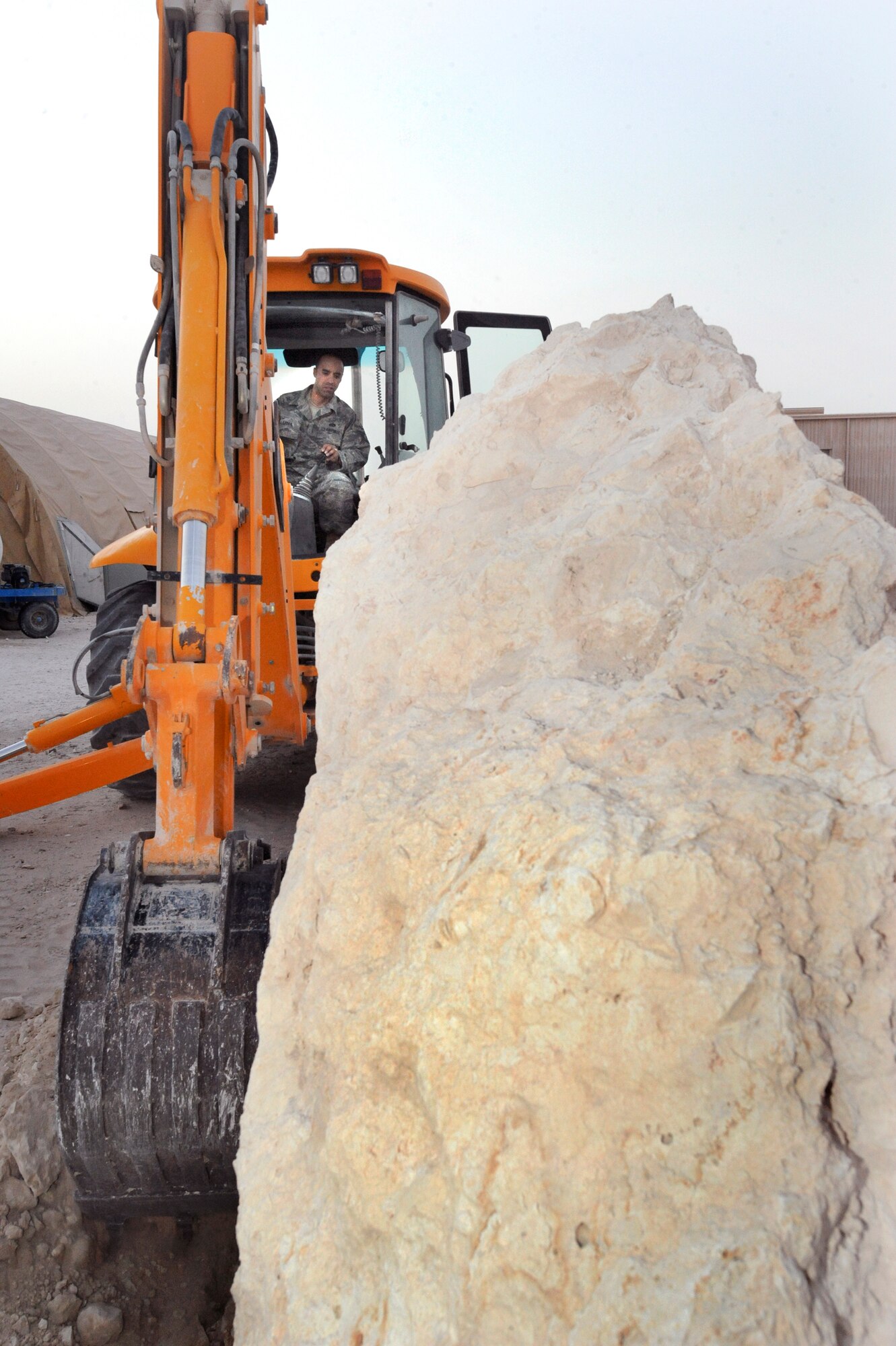 Tech. Sgt. Peter Lagos, a pavement and equipment operator better known as a "dirt boy" from the 379th Expeditionary Civil Engineer Squadron, breaks ground using a back hoe to move the memorial stone for Master Sgt. Evander E. "Andy" Andrews here, May 15, 2009, in and undisclosed location in Southwest Asia.  The memorial stone will be placed in front of the coalition compound movie theater and the theater will be renamed the Master Sgt. Evander E. "Andy" Andrews Memorial Theater once the stone is in its final resting place; Master Sgt. Andrews was Operation Enduring Freedom's first fatality. Sergeant Lagos is native to San Jose, Calif. and is deployed from Travis Air Force Base, Calif., in support of Operations Iraqi and Enduring Freedom and Combined Joint Task Force - Horn of Africa. (U.S. Air Force Photo by Staff Sgt. Joshua Garcia/released)