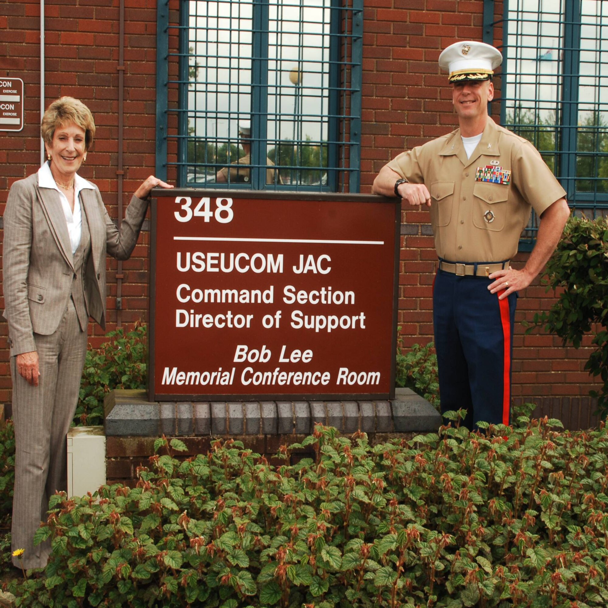 Mrs. Peggy Lee and JAC Commander Marine Corps Colonel Pete Devlin stand by the new sign outside the building on RAF Molesworth where the "Bob Lee Memorial Conference Room" was dedicated on May 15, 2009.  Mr. Robert E. "Bob" Lee served as a purchasing agent at the JAC from 2003 until 2008 as part of a career of service to the nation spanning 26 years of service in the U.S. Air Force and 21 years of federal civil service. (U.S. Air Force photo by Staff Sgt. Chad E. Chisholm)