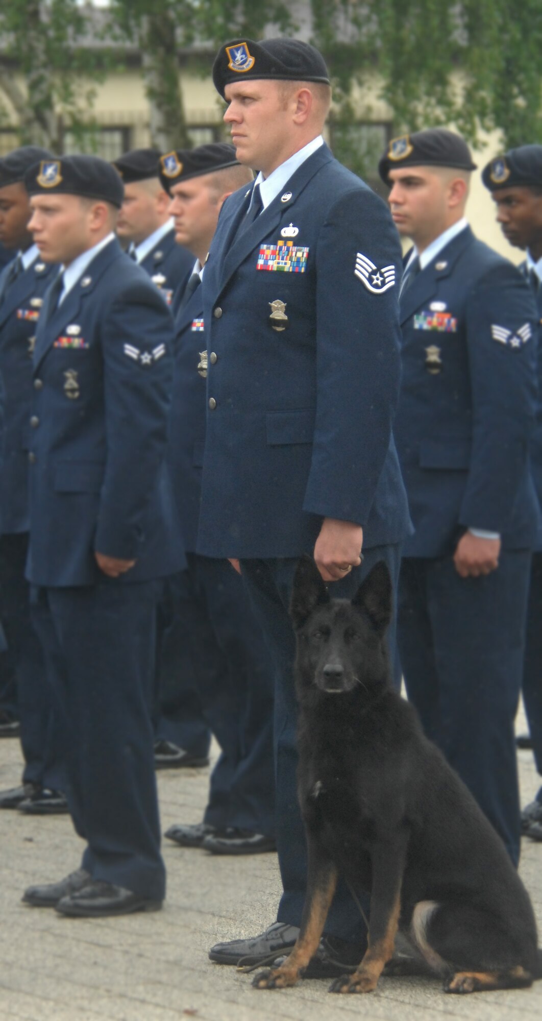 SPANGDAHLEM AIR BASE, GERMANY-- Staff Sgt. Chad Brown, 52nd Security Forces Squadron military working dog trainer, and his military working dog, Arena, stand at attention during retreat May 15, 2009.  The 52nd SFS held a retreat ceremony in memory of law enforcement officials, both civilian and military, who lost their lives during the past year. (U.S. Air Force photo by Master Sgt. Bill Gomez) 