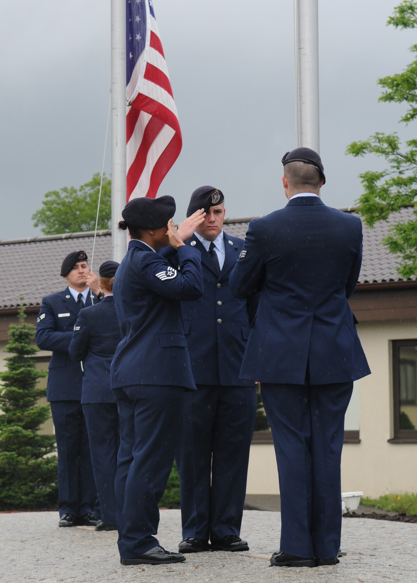 SPANGDAHLEM AIR BASE, Germany -- Members of the 52nd Security Forces Squadron salute both the German and American flag during a formal retreat ceremony May 15, 2009.  The 52nd SFS honored their fallen brethren during Police Week May 11-15.  (U.S. Air Force photo by Staff Sgt. Heather M. Norris)