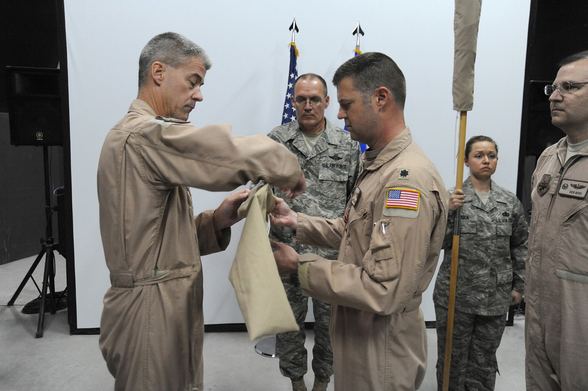 Col. Kyle Garland, 380th Expeditionary Operations Group, commander and Lt. Col. Robert Haines retire the flag of the 963rd Expeditionary Airborne Air Control Squadron, May 9 at an undisclosed location in Southwest Asia. The 964th EAACS was activated taking over for the 963rd EAACS mission. (U.S. Air Force photo by Senior Airman Brian J. Ellis) (Released)