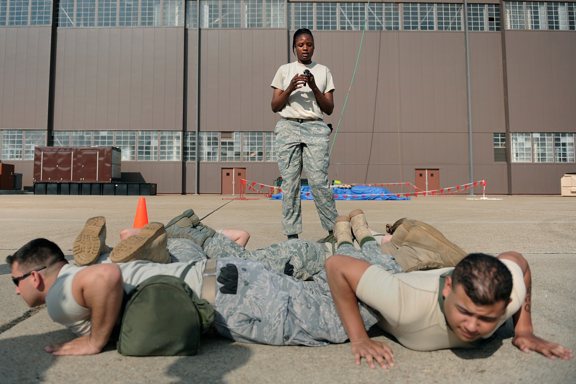 LANGLEY AIR FORCE BASE, Va. -- Tech. Sgt. Carmeeka Jackson, 1st Security Forces Squadron assistant non-commissioned officer of training, watches the time during the team push-up station of the Strong Man Competition obstacle course, here May 15.  1st SFS Airmen and civilians divided into 4-man teams to complete the obstacle course designed to build physical endurance and unit cohesion during National Police Week.  (U.S. Air Force photo/Senior Airman Vernon Young)