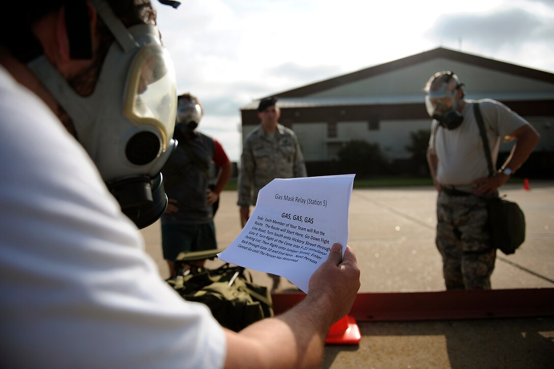 LANGLEY AIR FORCE BASE, Va. -- Mr. Rick Kellner, 1st Security Forces Squadron resources advisor, leads his team through the gas mask station of the Strong Man Competition obstacle course, here May 15.  1st SFS Airmen and civilians divided into 4-man teams to complete the obstacle course designed to build physical endurance and unit cohesion during National Police Week.  (U.S. Air Force photo/Senior Airman Vernon Young)