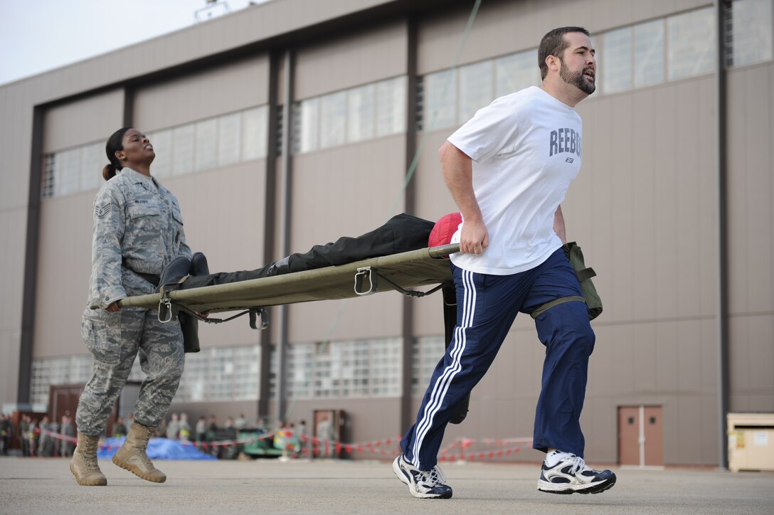 LANGLEY AIR FORCE BASE, Va. -- Mr. Rick Kellner, 1st Security Forces Squadron resources advisor, leads Staff Sgt. Ursula Warner, 1st SFS individual mobilization augmentee, during the litter carry station of the Strong Man Competition obstacle course, here May 15.  1st SFS Airmen and civilians divided into 4-man teams to complete the obstacle course designed to build physical endurance and unit cohesion during National Police Week.  (U.S. Air Force photo/Senior Airman Vernon Young)