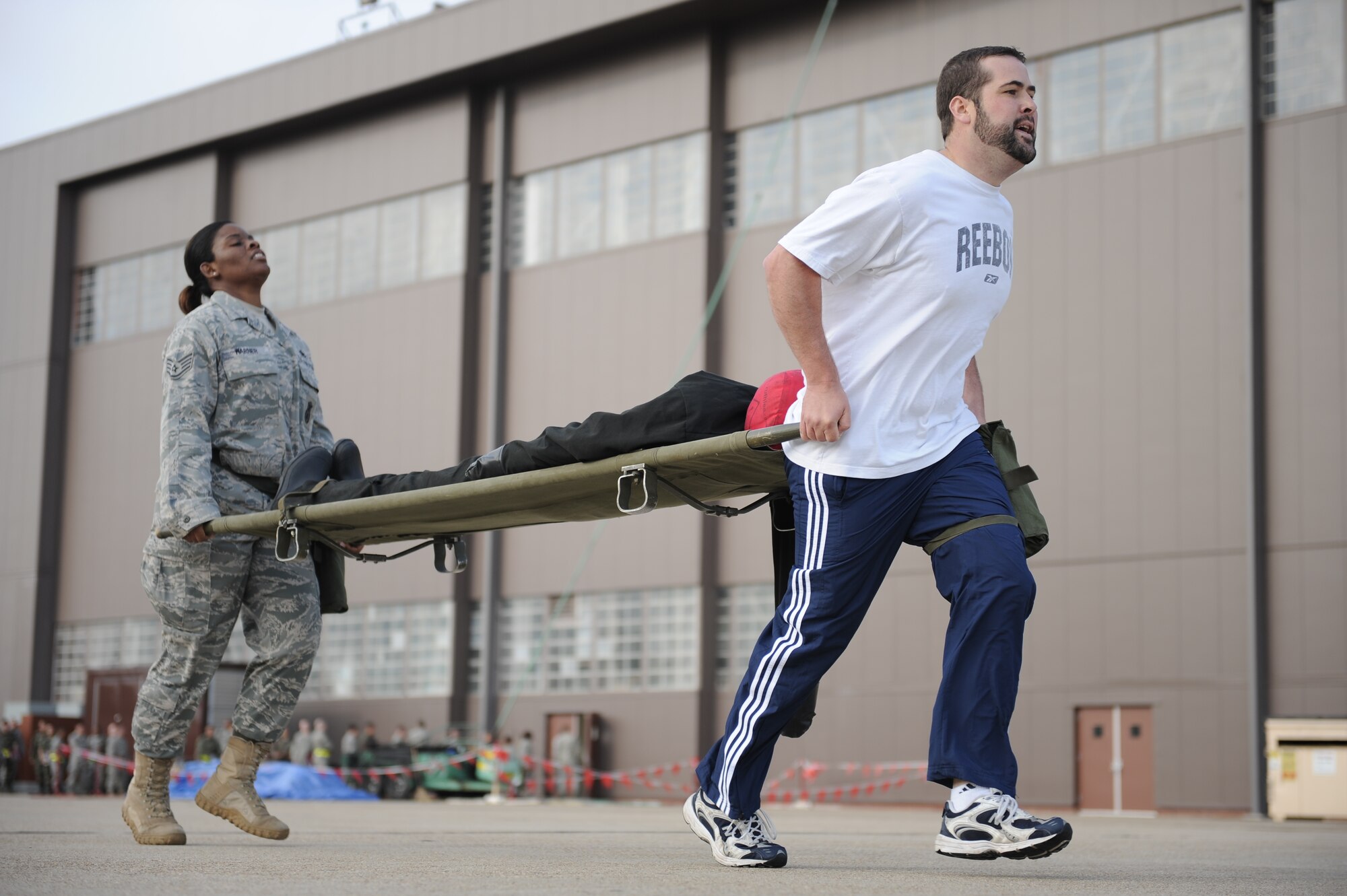 LANGLEY AIR FORCE BASE, Va. -- Mr. Rick Kellner, 1st Security Forces Squadron resources advisor, leads Staff Sgt. Ursula Warner, 1st SFS individual mobilization augmentee, during the litter carry station of the Strong Man Competition obstacle course, here May 15.  1st SFS Airmen and civilians divided into 4-man teams to complete the obstacle course designed to build physical endurance and unit cohesion during National Police Week.  (U.S. Air Force photo/Senior Airman Vernon Young)