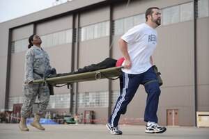 LANGLEY AIR FORCE BASE, Va. -- Mr. Rick Kellner, 1st Security Forces Squadron resources advisor, leads Staff Sgt. Ursula Warner, 1st SFS individual mobilization augmentee, during the litter carry station of the Strong Man Competition obstacle course, here May 15.  1st SFS Airmen and civilians divided into 4-man teams to complete the obstacle course designed to build physical endurance and unit cohesion during National Police Week.  (U.S. Air Force photo/Senior Airman Vernon Young)