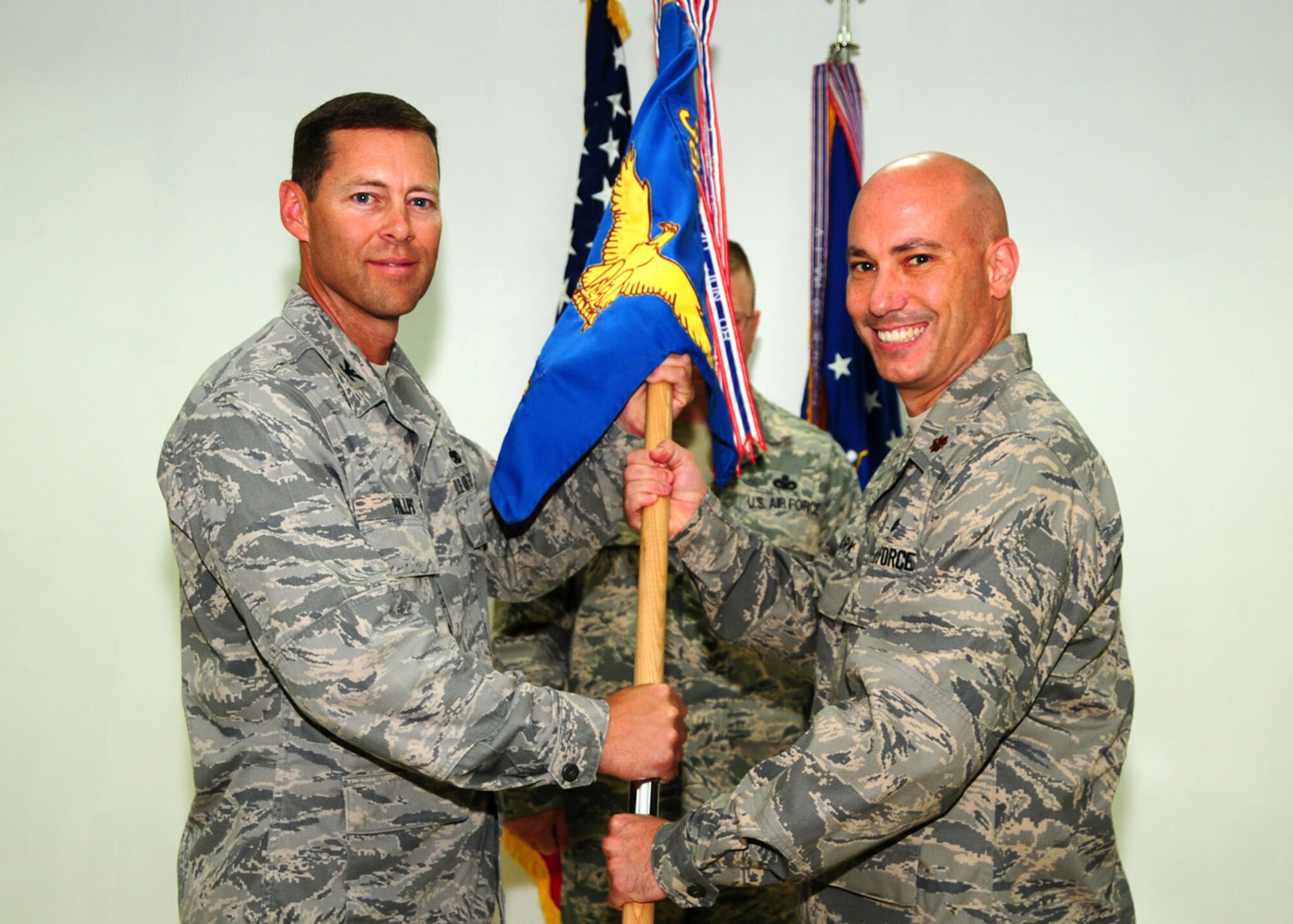 SOUTHWEST ASIA -- Maj. John Clark assumes command of the 386th Expeditionary Maintenance Squadron from Col. Herbert Phillips, 386th Expeditionary Maintenance Group commander, at an air base in Southwest Asia, May 16. Major Clark is currently deployed from Dyess Air Force Base, Texas. (U.S. Air Force photo/ Senior Airman Courtney Richardson)