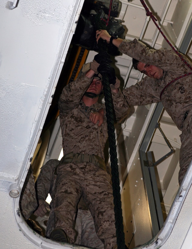 ::n::Sgt. Jeremy L. Leaders, right, a fire direction chief with 81mm Mortar Platoon, Weapons Company, Battalion Landing Team, 3rd Battalion, 2nd Marine Regiment, 22nd Marine Expeditionary Unit, and native of Oak Harbor, Ohio, assists Marines with proper descent techniques during the platoon's fast-rope qualification training aboard USS Bataan May 18, 2009. The 22nd MEU, deployed aboard the ships of the Bataan Amphibious Ready Group, is currently serving as the theater reserve force for U.S. European Command.::n::(Official Marine Corps photo by Cpl. Justin M. Martinez) ::n::