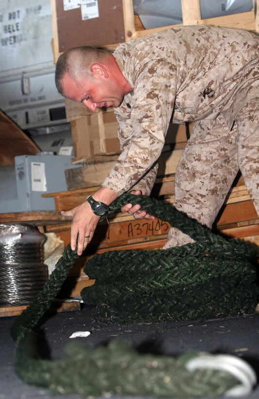 ::n::Staff Sgt. Jacob L. Smith, a section leader for 81mm Mortar Platoon, Weapons Company, Battalion Landing Team, 3rd Battalion, 2nd Marine Regiment, 22nd Marine Expeditionary Unit and native of Decatur, Ill., reels up the rope his Marines used to conduct fast-rope qualification training aboard USS Bataan May 18, 2009. The 22nd MEU, deployed aboard the ships of the Bataan Amphibious Ready Group, is currently serving as the theater reserve force for U.S. European Command.::n::(Official Marine Corps photo by Cpl. Justin M. Martinez)::n::
