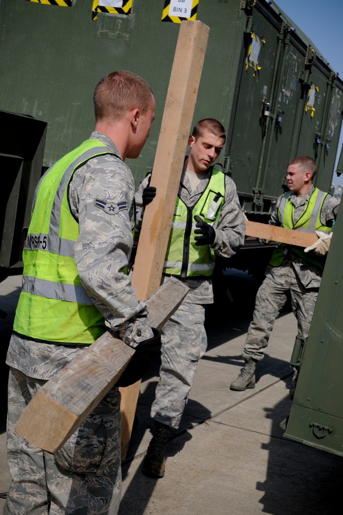 MISAWA AIR BASE, Japan -- Airman 1st Class Alex Russell, Airman 1st Class Michael Theroux and Airman Kiernan Box prepare to load cargo during an initial response readiness exercise May 18, 2009. The exercise tested the base's ability to quickly deploy jets and personnel during heightened threat levels. (U.S. Air Force photo by Senior Airman Jamal D. Sutter)